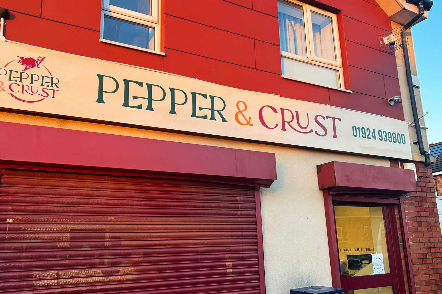 Pepper & Crust restaurant fascia sign with playful serif typography in red, green, and orange
