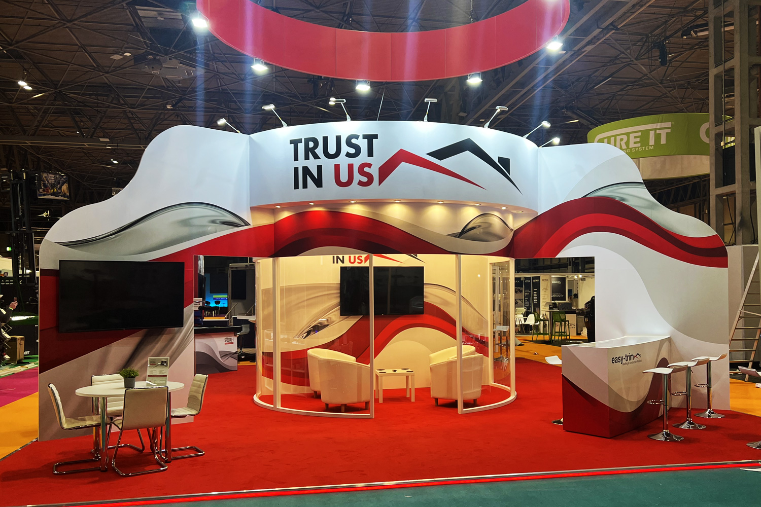 Curved exhibition panel design with integrated rotating screen and corporate branding, installed in a trade show environment
