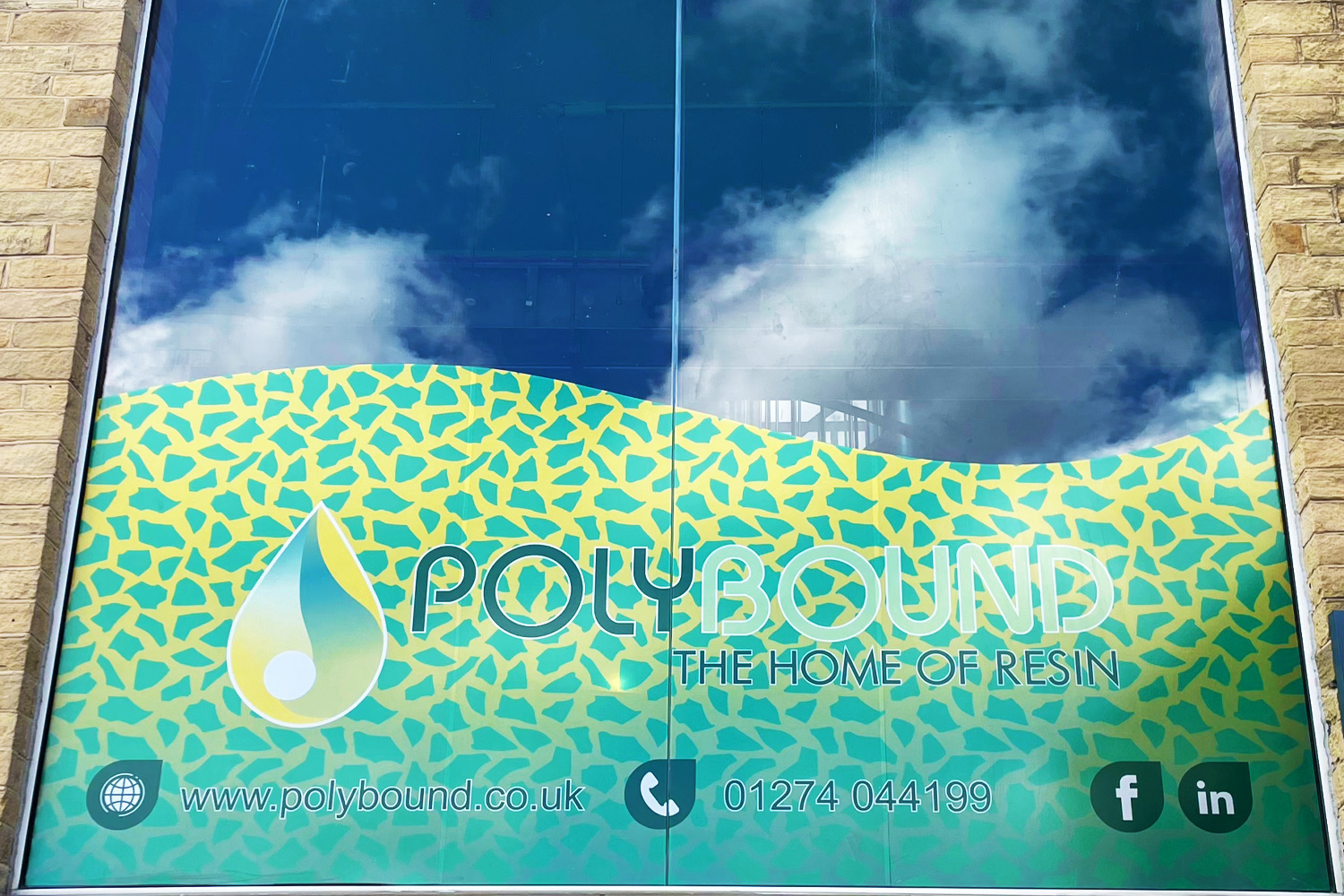 Vibrant window graphic for Polybound with abstract resin-inspired pattern, company logo, and contact information on glass frontage