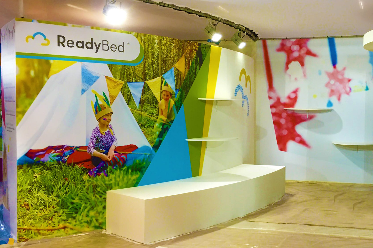Branded ReadyBed Kids cardboard display stand showcasing children's bedding products in a retail environment
