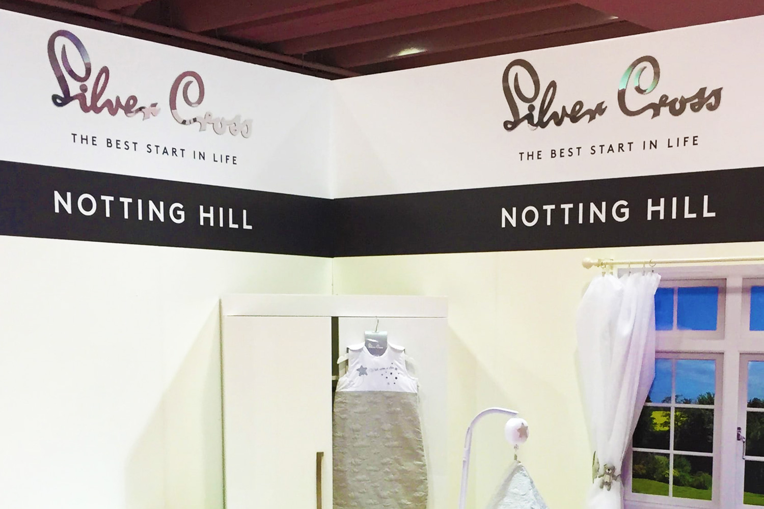 Elegant white and black retail-style exhibition stand for Silver Cross featuring Notting Hill branding and baby sleep products