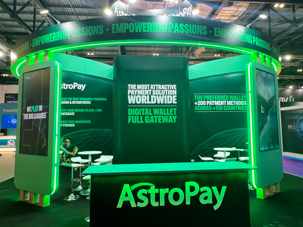 Striking green AstroPay exhibition stand with bold branding and signage, created and installed by G4 Graphics at a large event