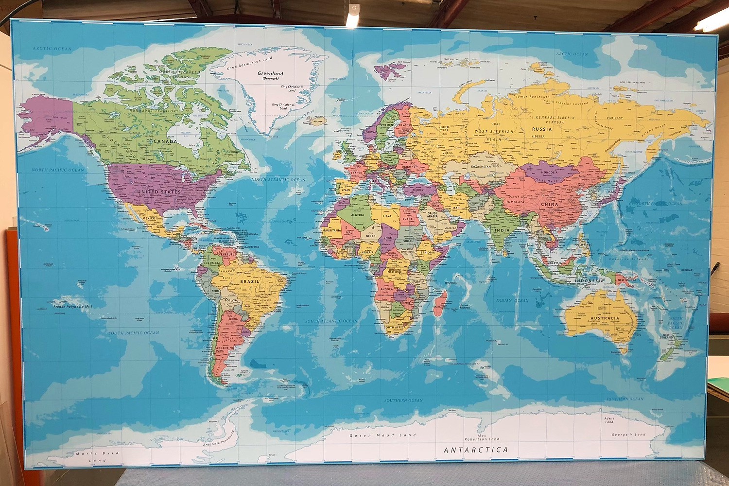 A vibrant and detailed world map graphic, perfect for schools, offices, or travel agencies, printed on durable material for large-scale wall display