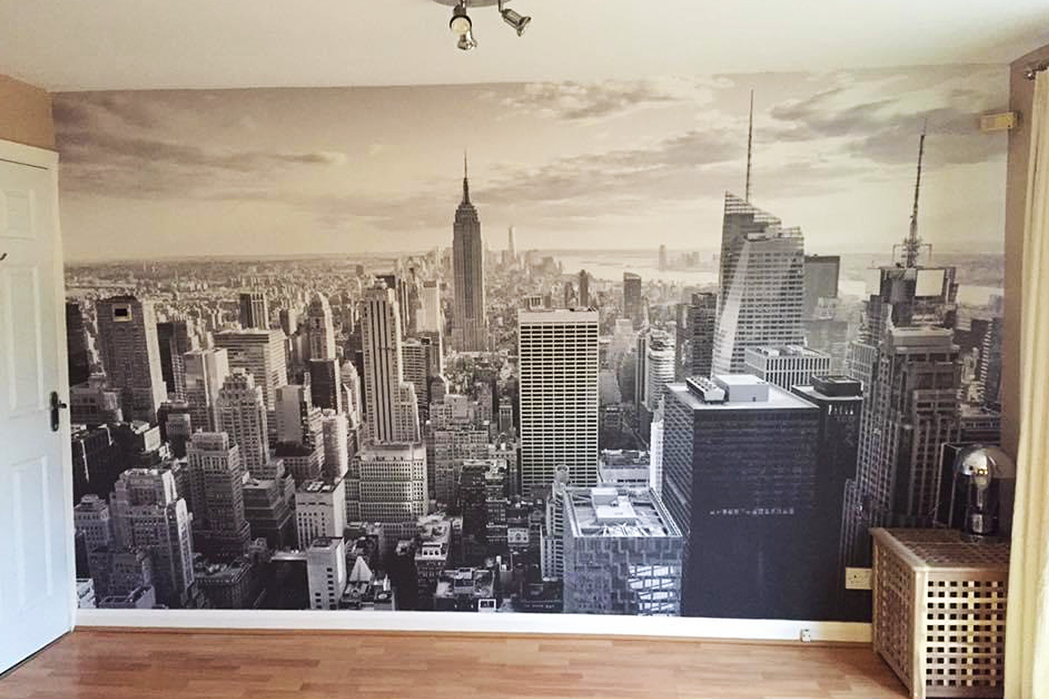 Monochrome mural of the New York City skyline covering an interior wall