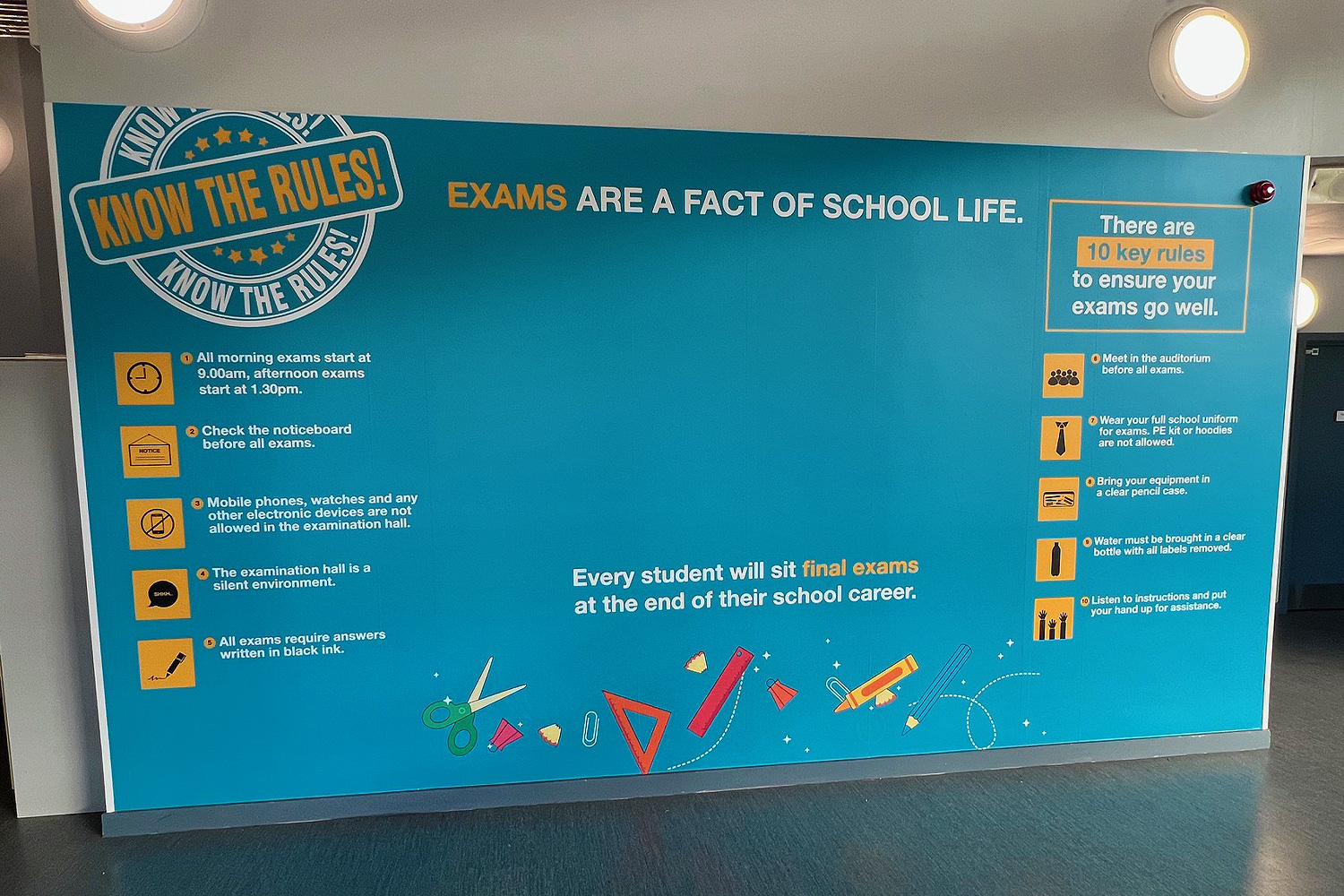 Blue educational wall graphic listing school exam rules with icons